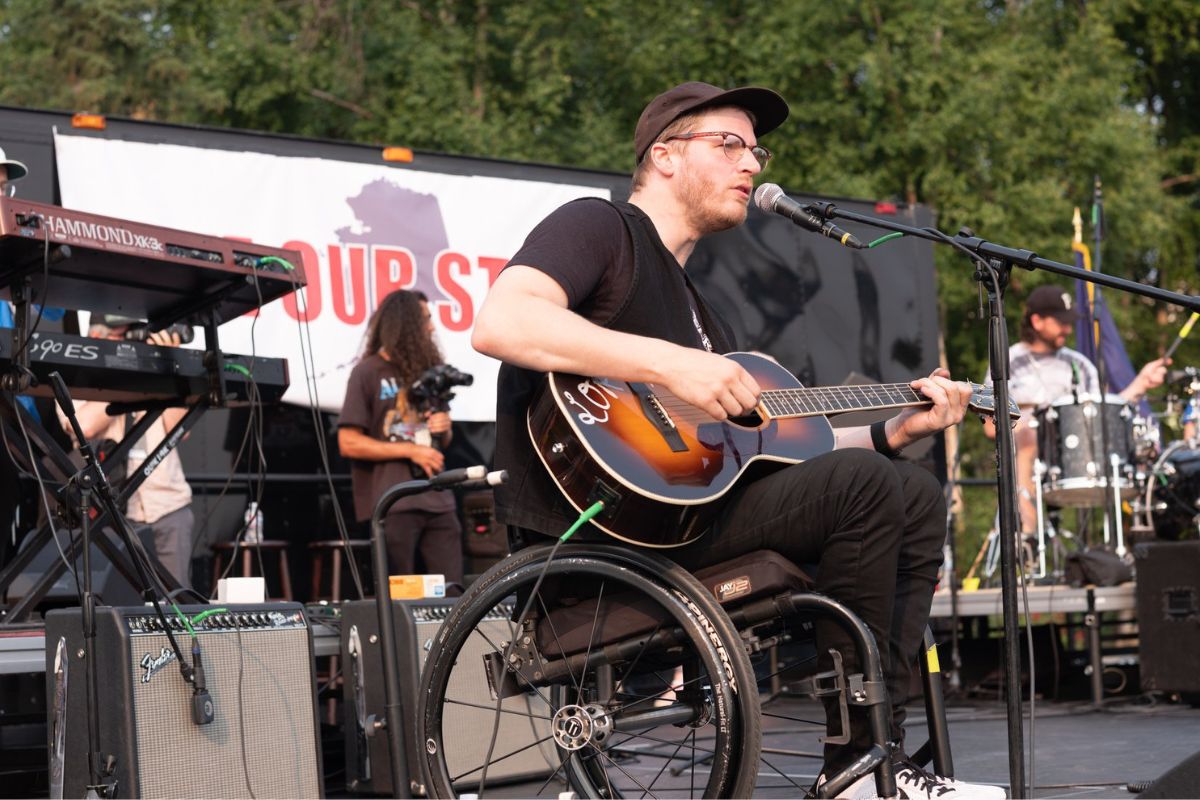 A man in a wheelchair performs on stage with passion