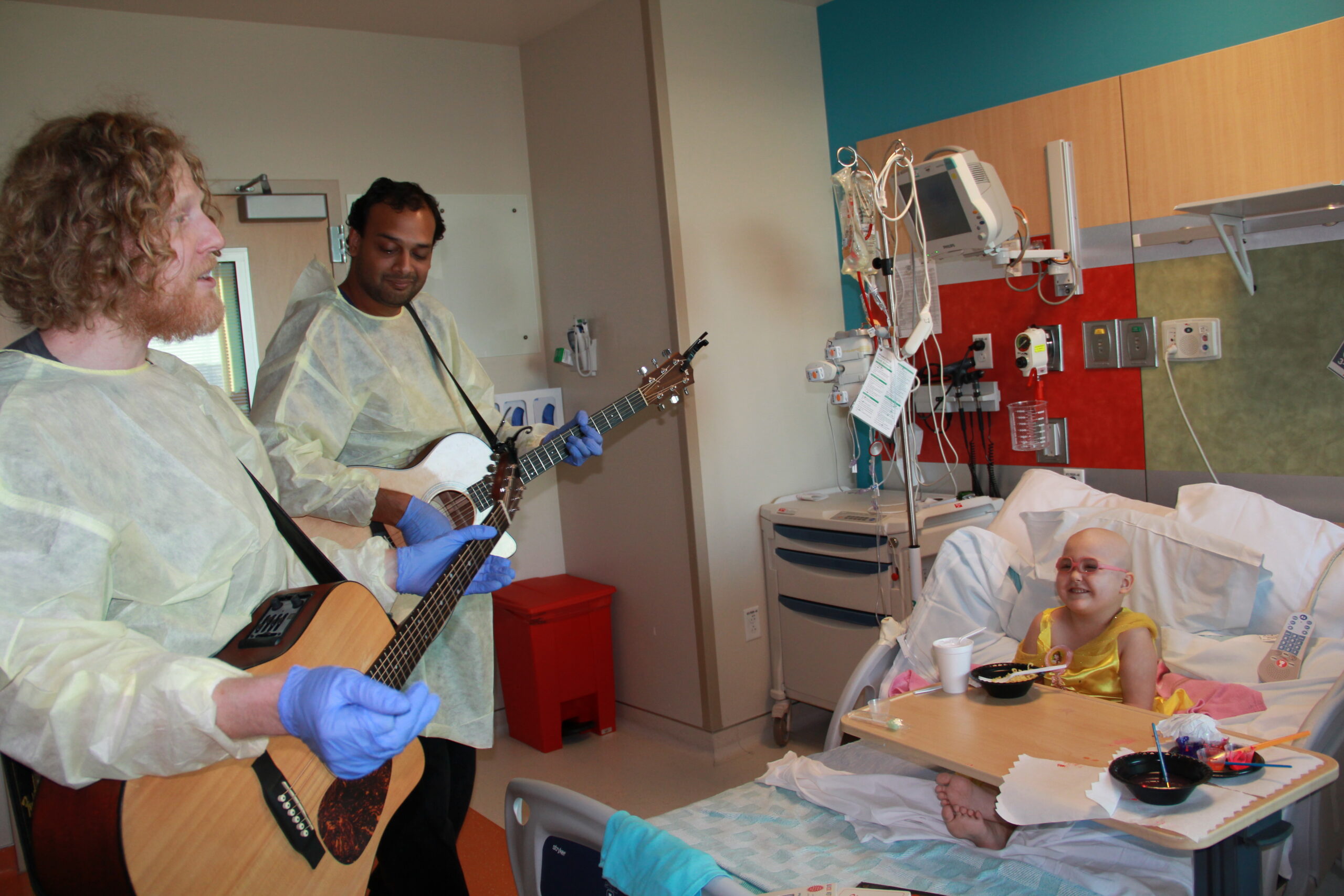 A man playing guitar in a hospital room