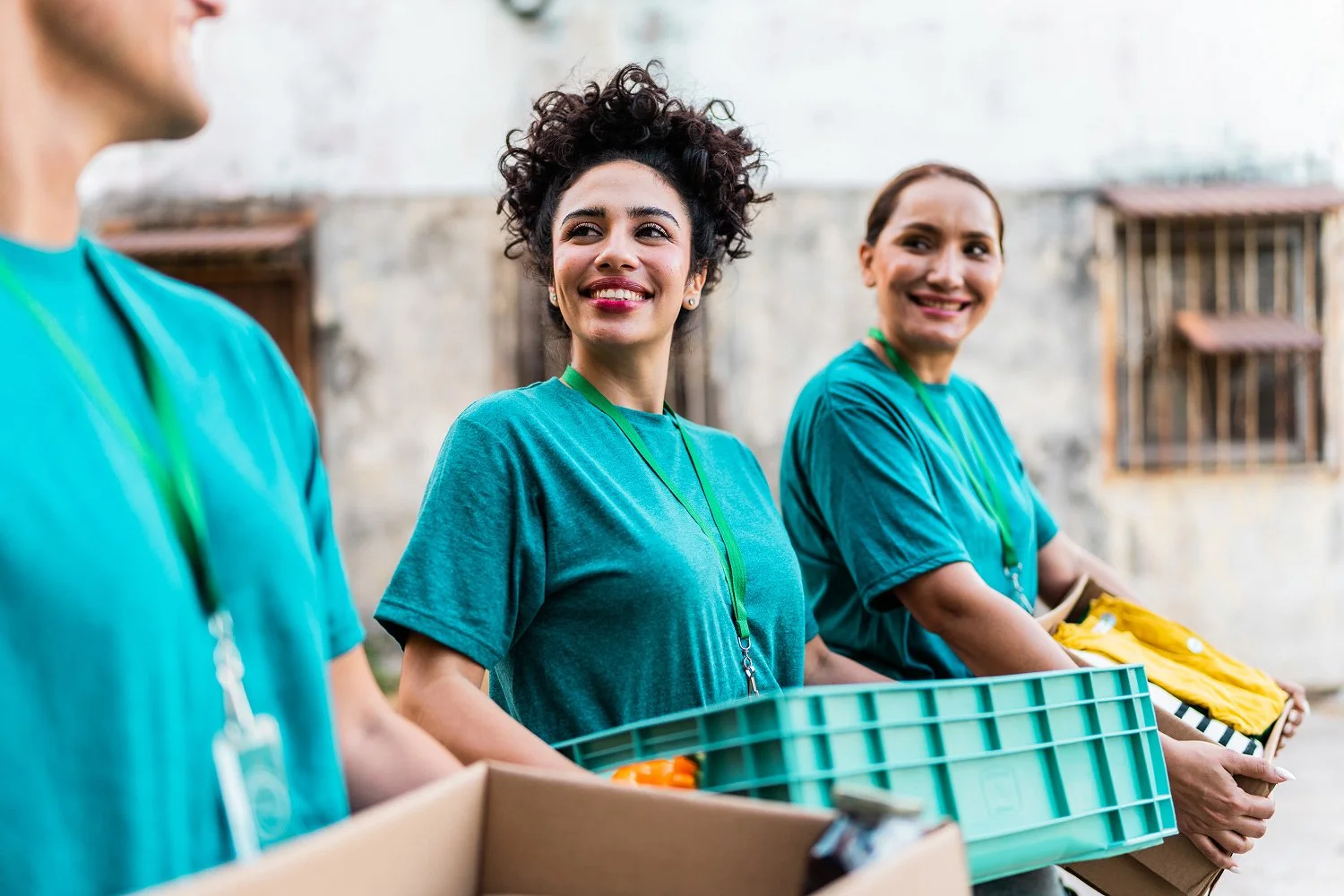 Man and 2 ladies carrying crates and boxes